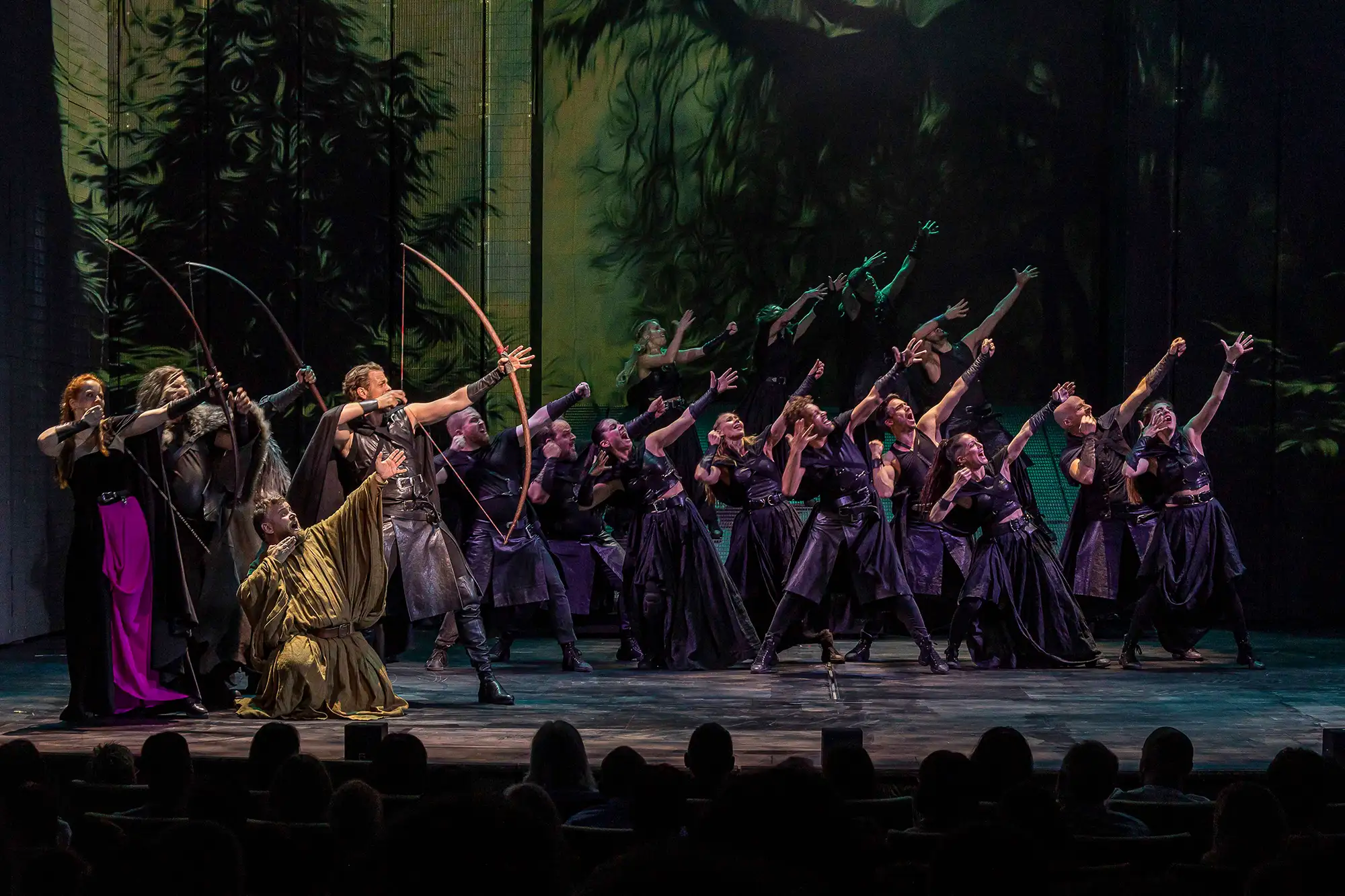 Musical Robin Hood Fulda - Eine Gruppe Menschen auf der Bühne die ihre Arme und einen Bogen mit Pfeil nach oben strecken